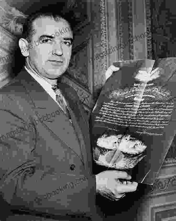 A Black And White Portrait Of Senator Joe McCarthy, A Serious Expression On His Face And Piercing Blue Eyes That Stare Directly At The Viewer. He Wears A Suit And Tie, And His Hair Is Neatly Parted. Behind Him Is A Blurred American Flag. Demagogue: The Life And Long Shadow Of Senator Joe McCarthy
